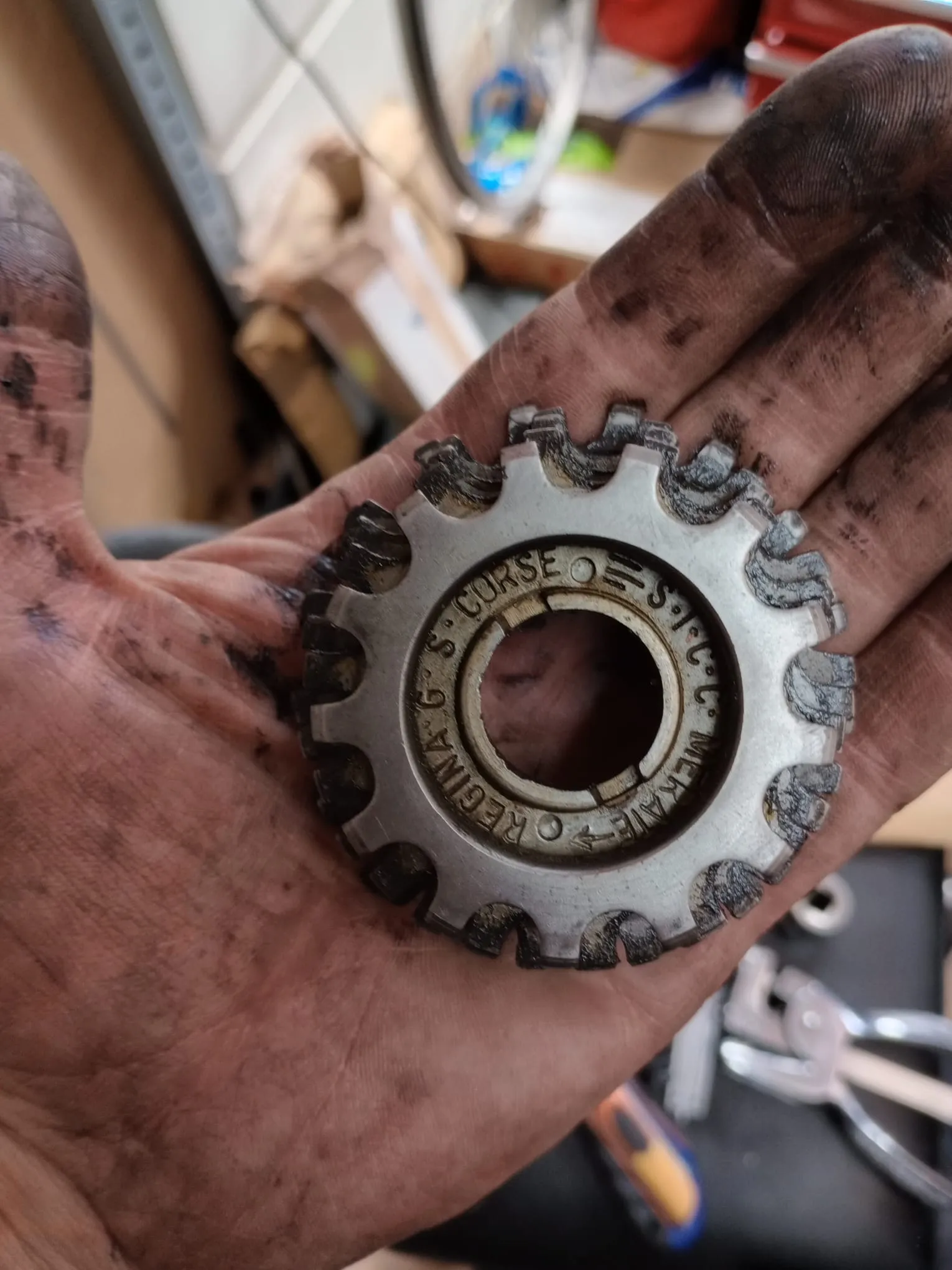 Piñón de bicicleta reparado sobre la mano del mecánico