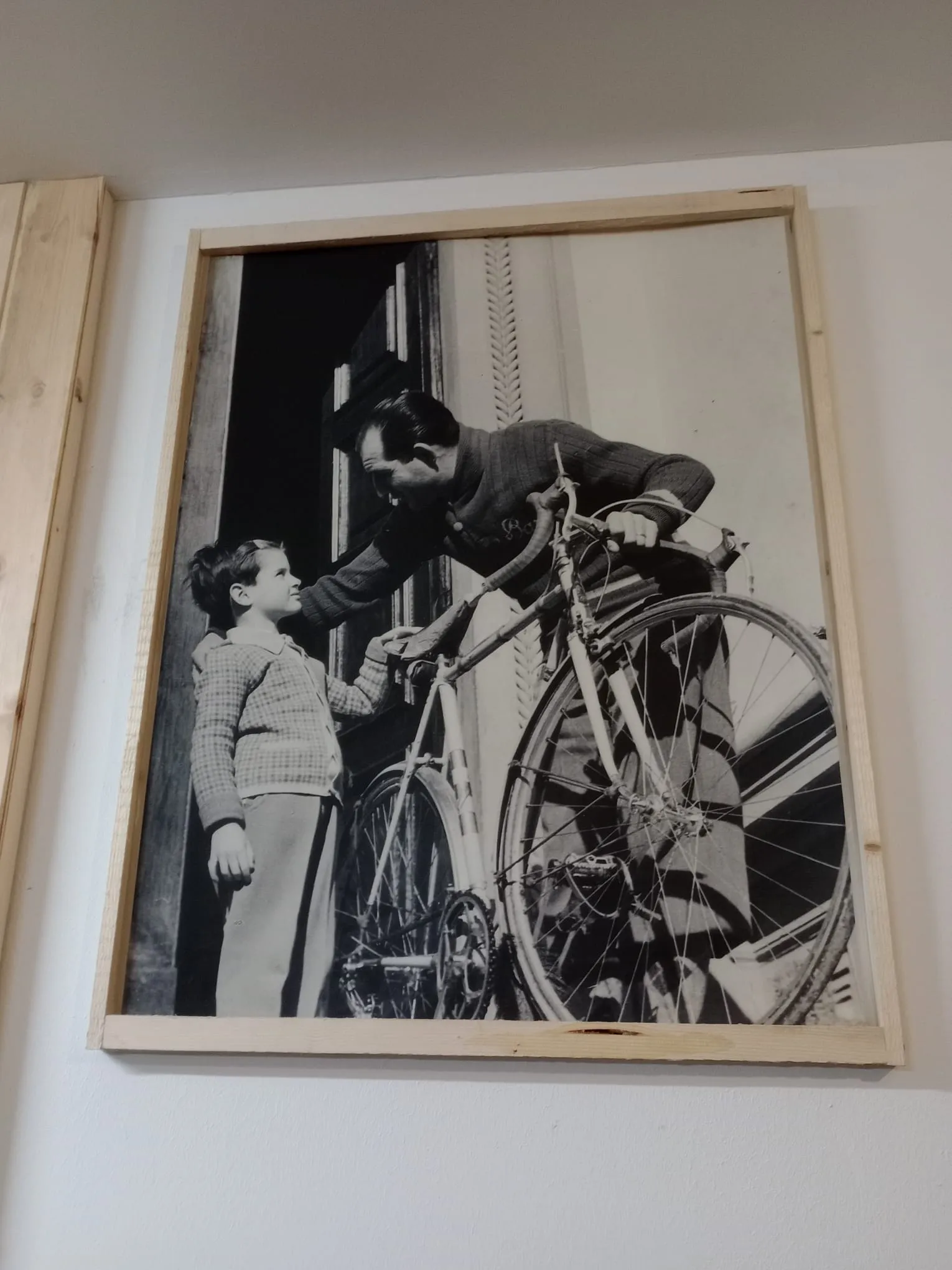Fotografía histórica de un ciclista con una niña y una bicicleta
